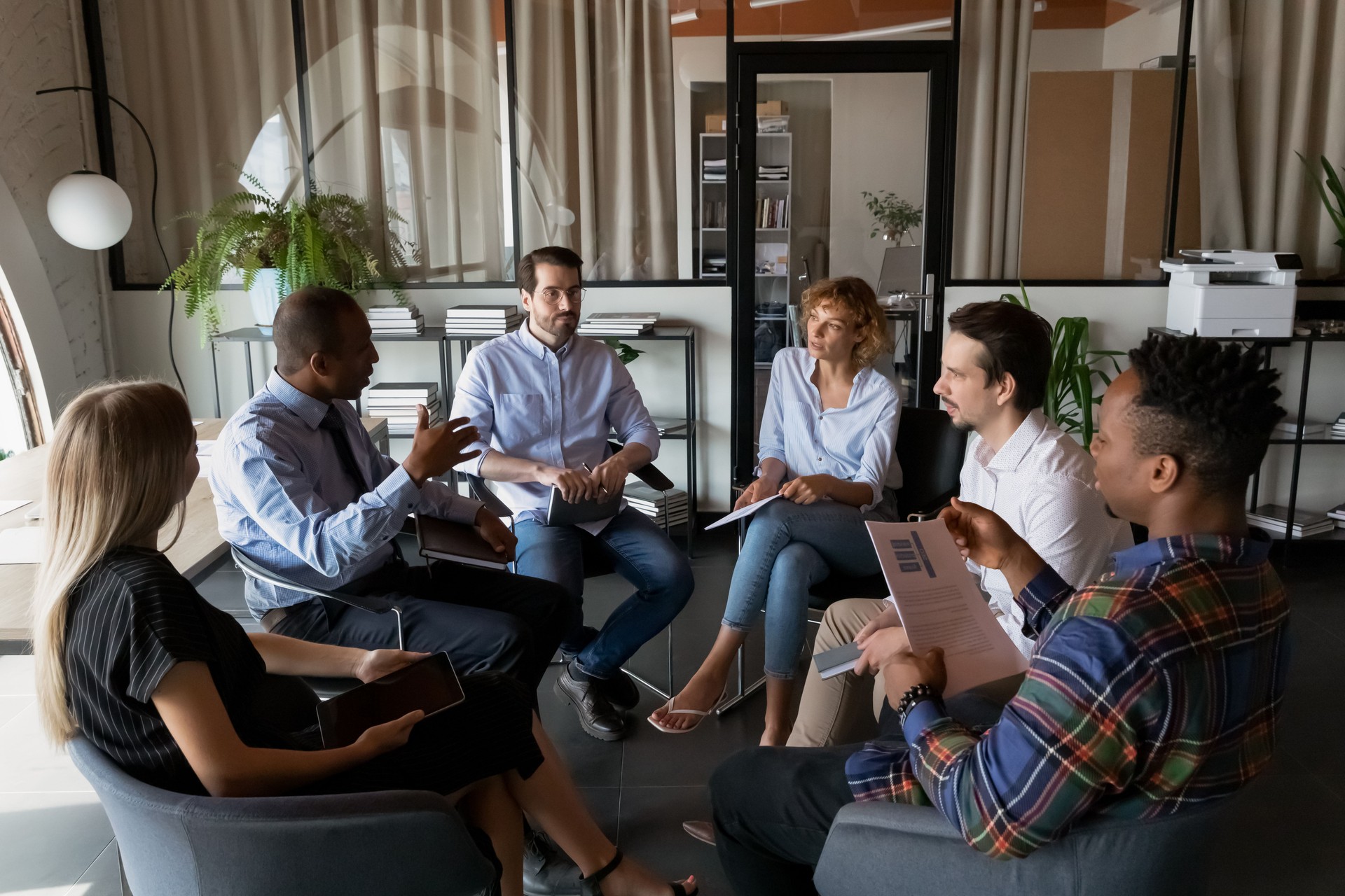 Multiethnic business team coworkers sitting in circle in office